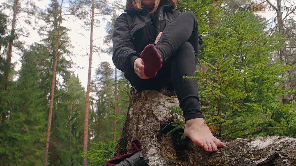 A Girl In Nature Took Off Her Boots And Shows Her Bare Feet