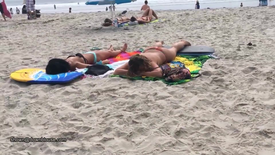 A beach voyeur is approching two nice girls because the bikini bra is so big that nipples are  visible