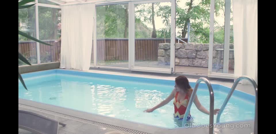 Old man shags a fresh brunette from behind at the  poolside.